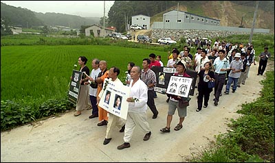  49재를 지낸 참가자들이 고인들의 영정을 모시고 사고현장으로 이동하고 있다.